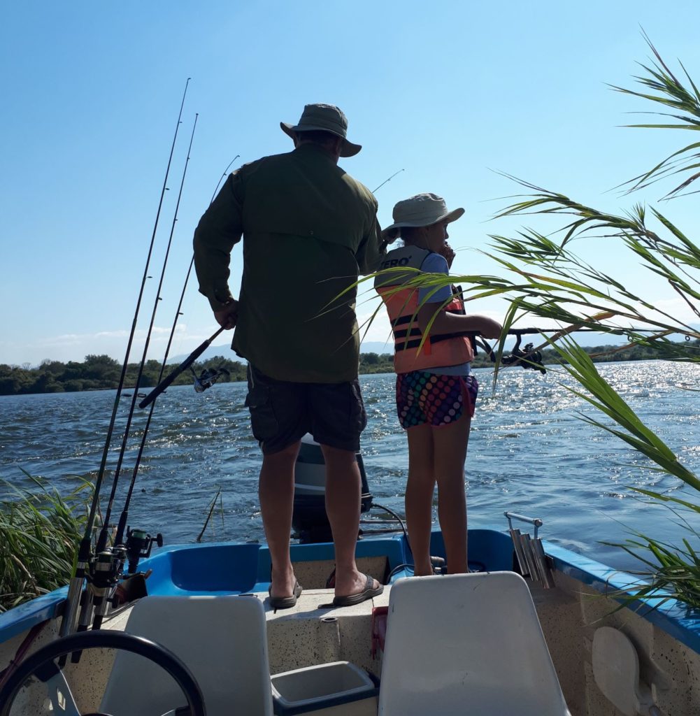 Father and daughter fishing.  Father showing leadership. 