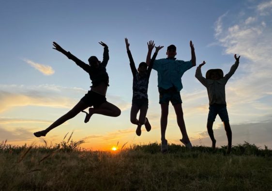 kids jumping in the sunset